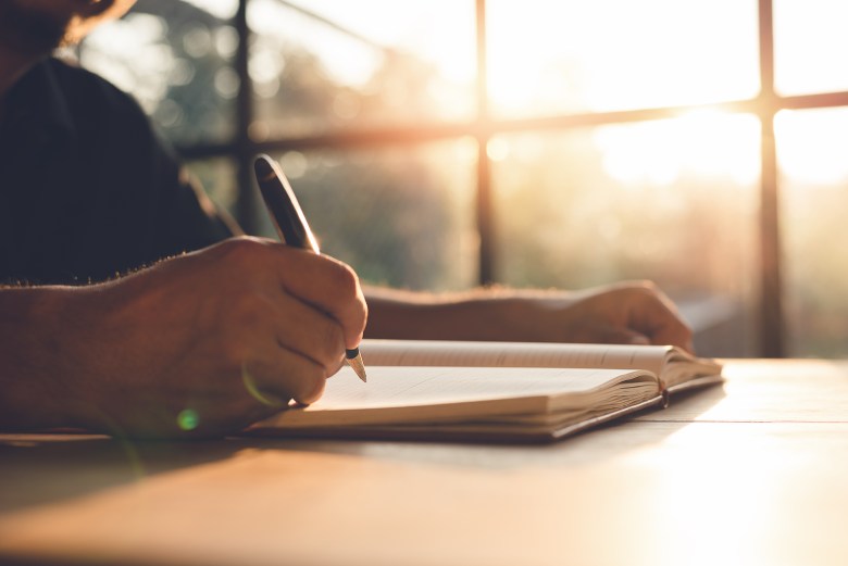 A person writes in their journal