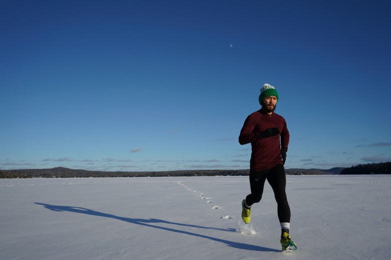 A person runs in a snowy field 