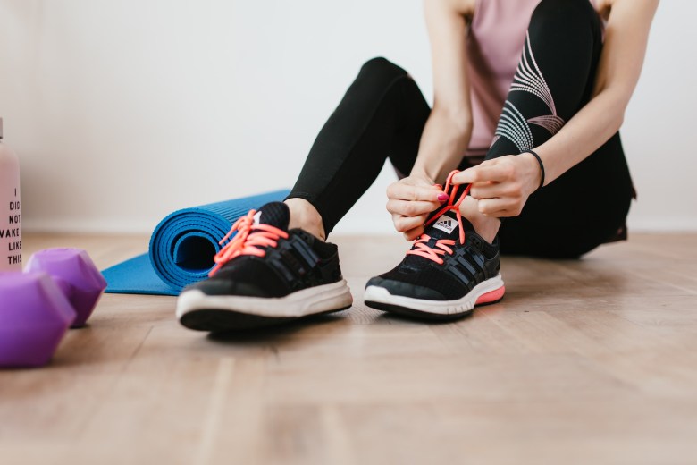 A person laces up their sneakers for a workout