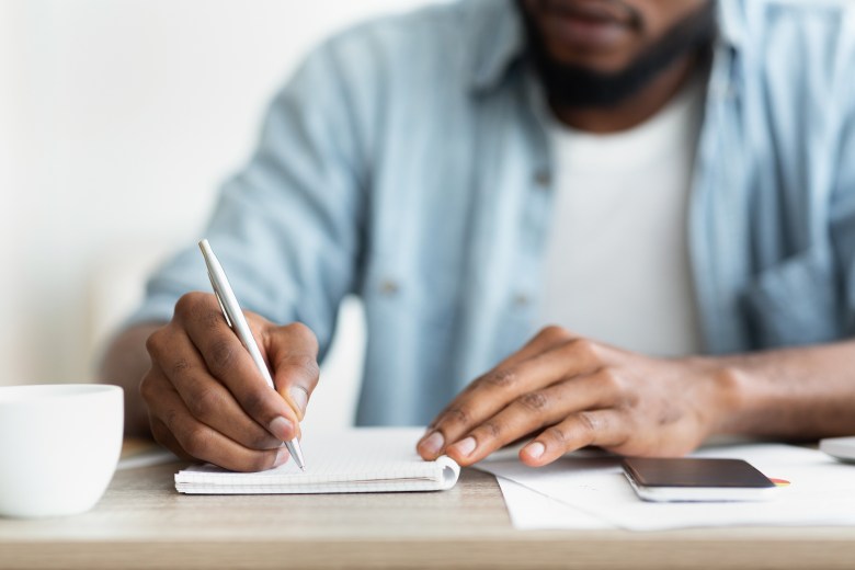A person writes in their journal for stress relief