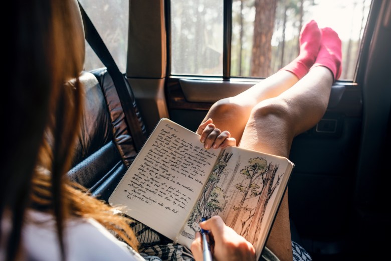 A person writes in their art journal