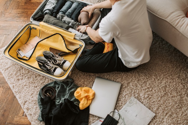 A man packs to return home after a trip with his travel journal