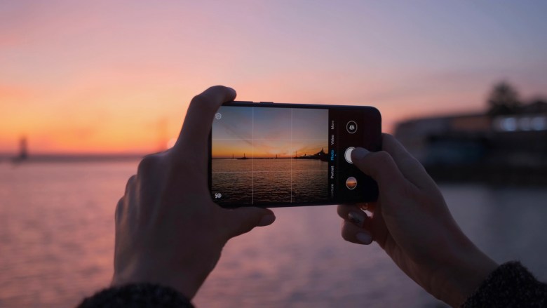 A person takes a photo on their smartphone for photo journaling