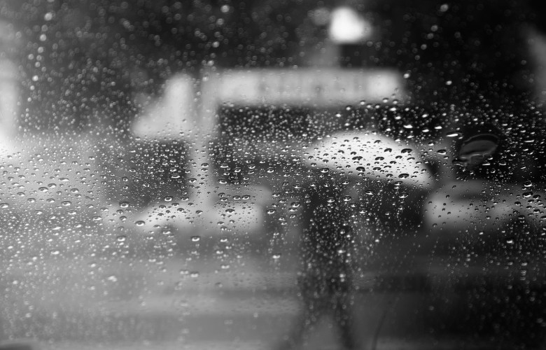 a person walks in the rain behind a foggy window as a metaphor for rumination