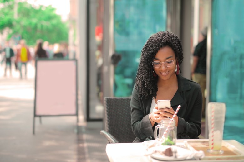 A woman uses a travel journal app while traveling. 