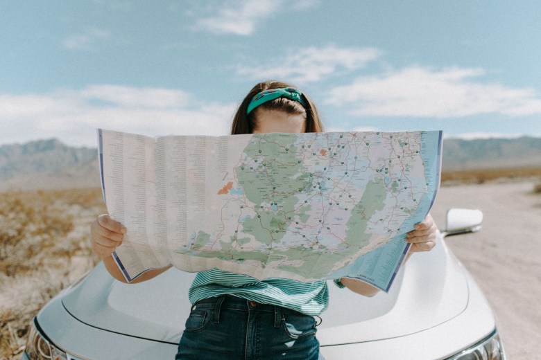 A woman looks at a map while traveling