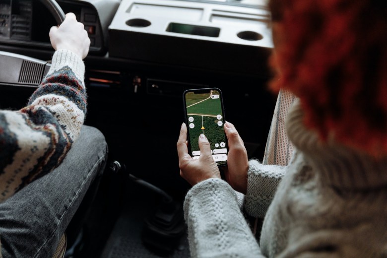 a person holds a map on their phone while travel journaling